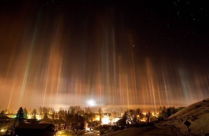 Columnas luminosas verticales en el cielo reflejadas sobre cristales de hielo